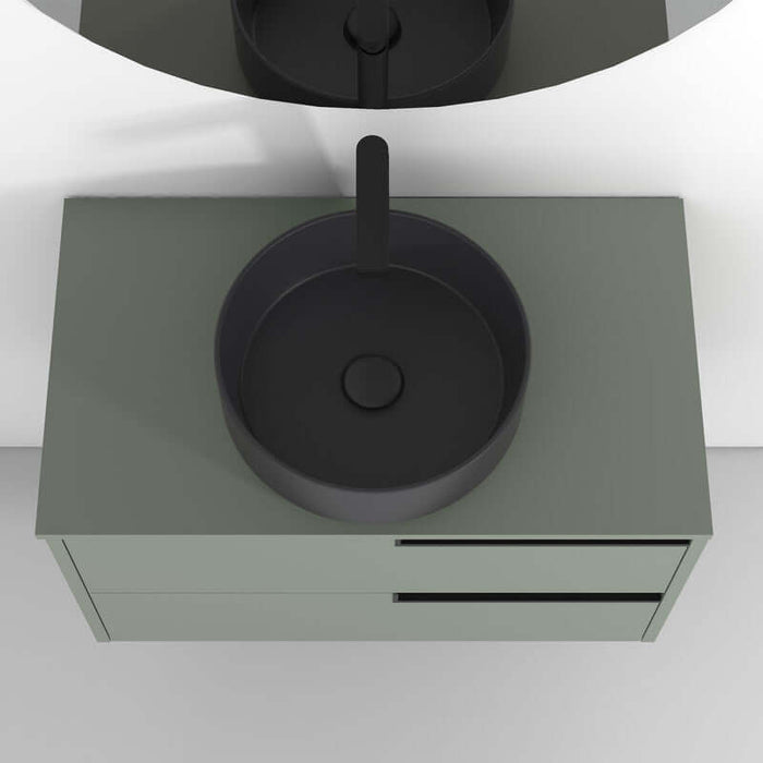 Vista superior de lavabo negro sobre mueble verde, ideal para baño moderno y funcional.